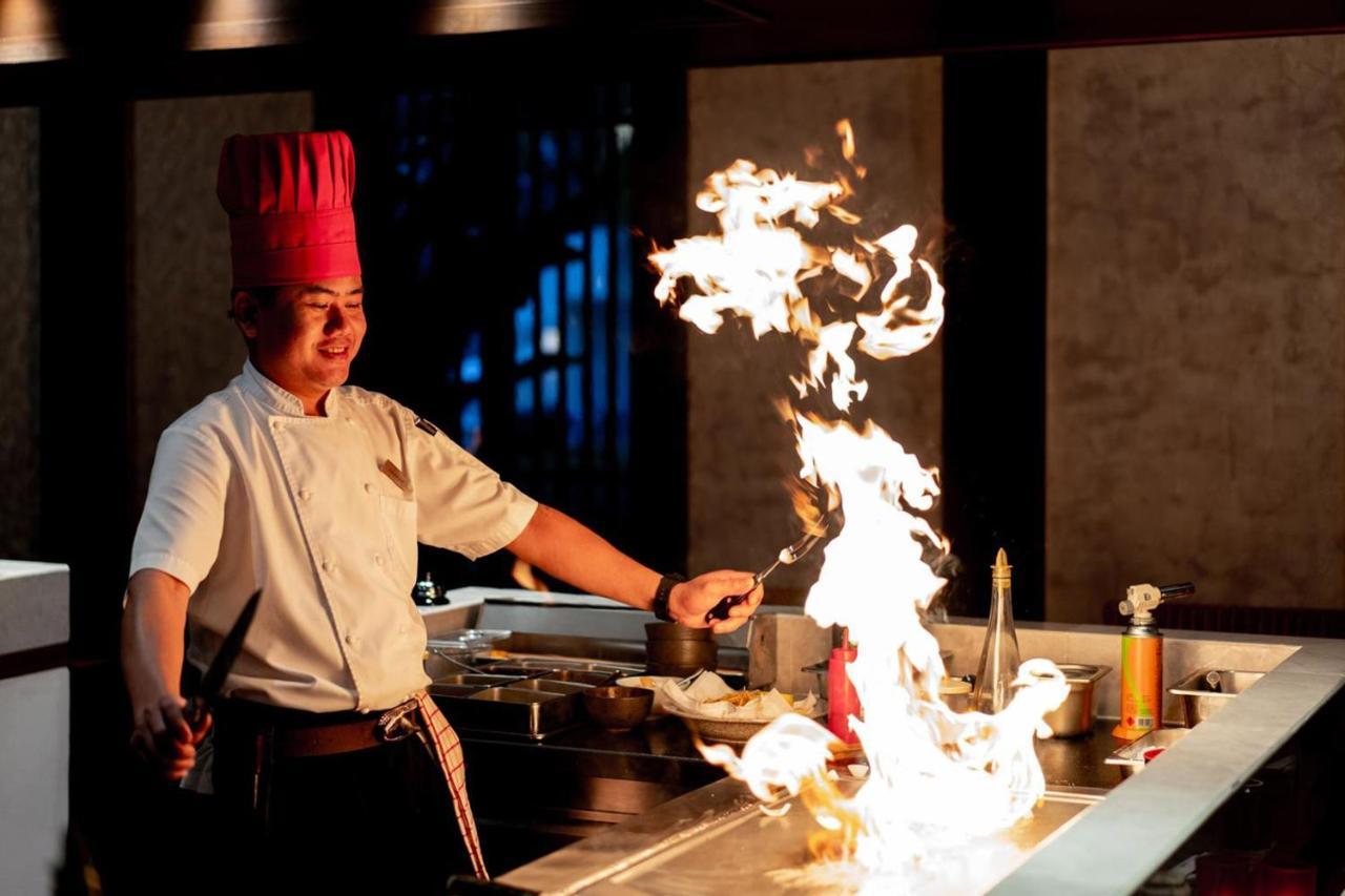 Jw Marriott Khao Lak Resort And Spa Bagian luar foto A chef cooking with a flaming wok